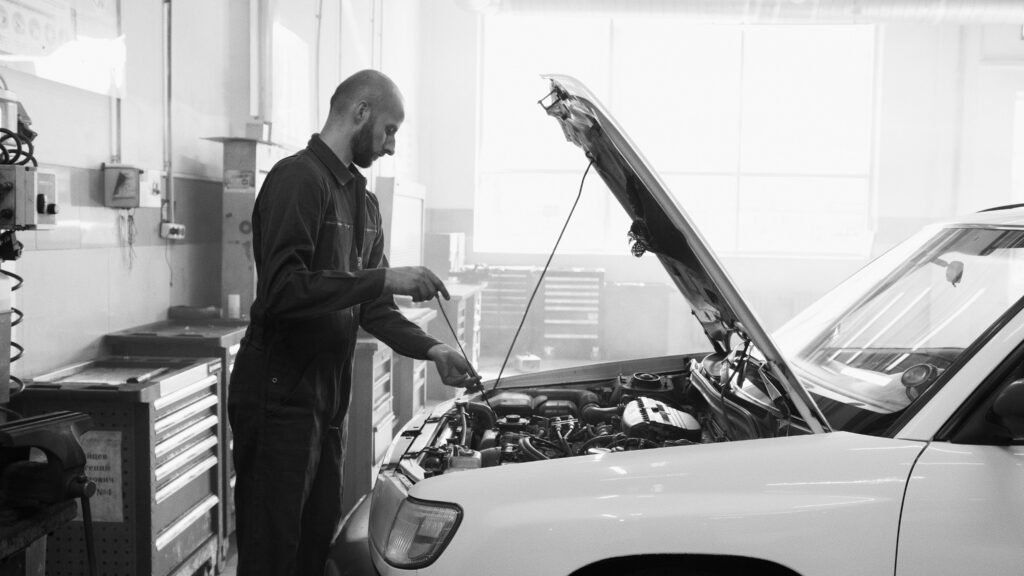 7 Answers to the Most Frequently Asked Questions About Automobile Mechanic in a garage performing engine maintenance on a vehicle.