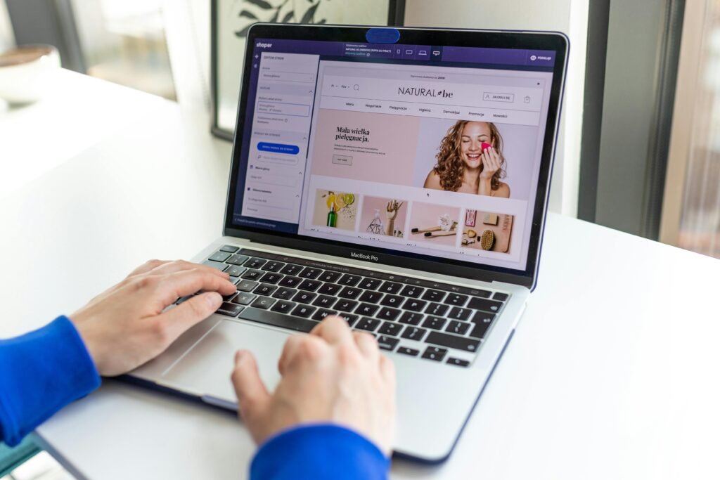 Rev Up Your E-commerce Engine by Starting a Thriving Shopify Store Hands typing on a laptop with an e-commerce website open, showcasing online shopping.